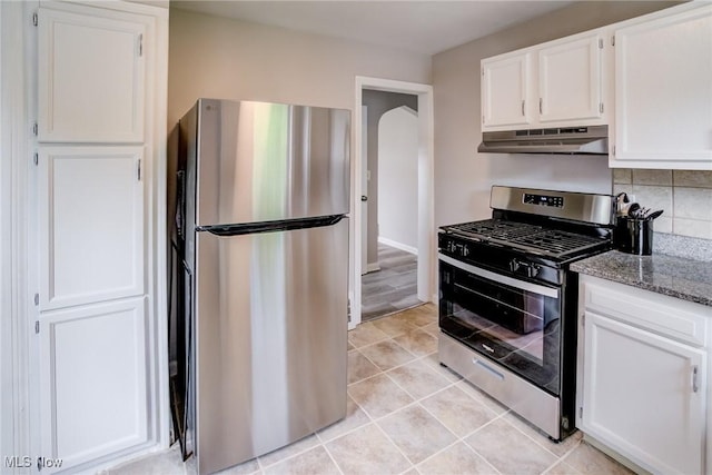 21411 Clare Ave, Maple Heights, OH 44137 - kitchen featuring appliances with stainless steel finishes, under cabinet range hood, white cabinetry, light stone countertops, and arched walkways