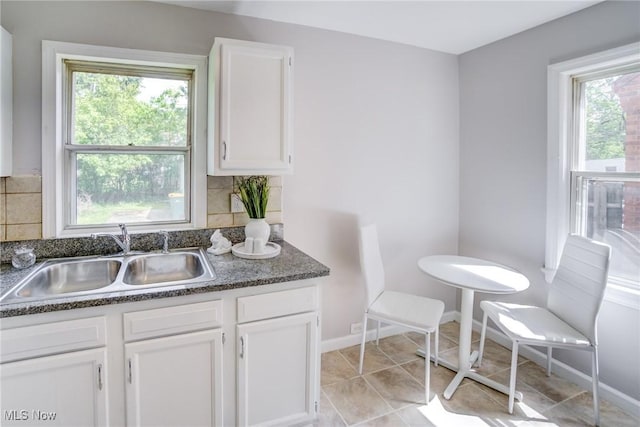 21411 Clare Ave, Maple Heights, OH 44137 - kitchen featuring a sink, white cabinetry, decorative backsplash, and dark countertops
