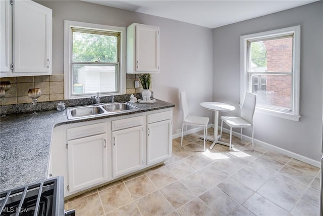 21411 Clare Ave, Maple Heights, OH 44137 - kitchen with a sink, plenty of natural light, white cabinetry, and decorative backsplash