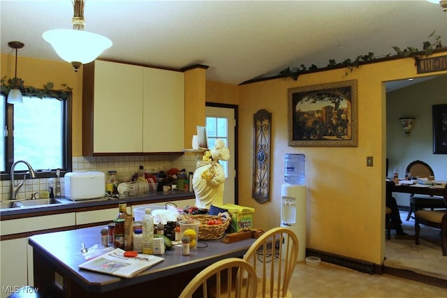 635 N Hametown Rd, Akron, OH 44333 - kitchen featuring a sink, lofted ceiling, light flooring, decorative backsplash, and hanging light fixtures