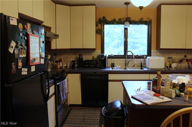 635 N Hametown Rd, Akron, OH 44333 - kitchen with black appliances, under cabinet range hood, a sink, decorative backsplash, and dark countertops
