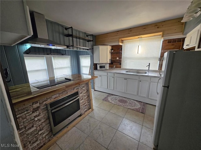 1264 Diagonal Rd, Akron, OH 44307 - kitchen with appliances with stainless steel finishes, white cabinets, a sink, open shelves, and wall chimney exhaust hood