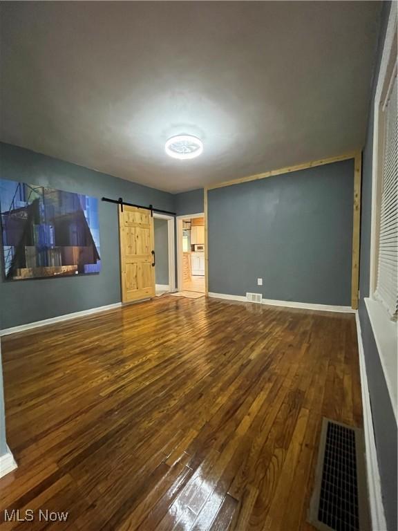 1264 Diagonal Rd, Akron, OH 44307 - unfurnished bedroom featuring hardwood / wood-style flooring, baseboards, and a barn door