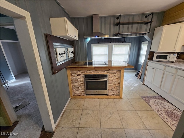 1264 Diagonal Rd, Akron, OH 44307 - kitchen featuring stainless steel oven, wall chimney range hood, white microwave, white cabinetry, and baseboards