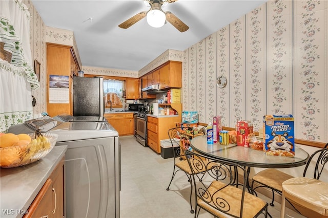 313 E 244th St, Euclid, OH 44123 - kitchen with appliances with stainless steel finishes, wallpapered walls, under cabinet range hood, stainless steel counters, and brown cabinetry