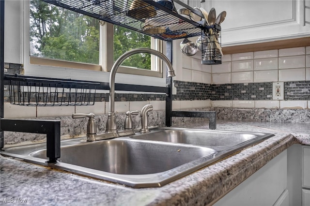 1654 Vicgross Ave, Akron, OH 44310 - kitchen view of a sink, backsplash, and white cabinetry