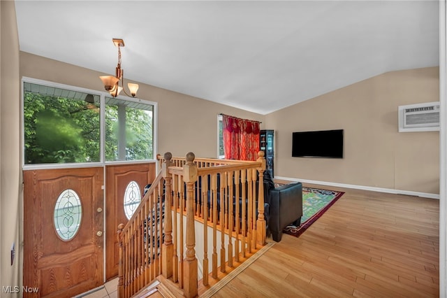 1654 Vicgross Ave, Akron, OH 44310 - foyer entrance featuring an AC wall unit, lofted ceiling, a chandelier, baseboards, and light wood-style floors