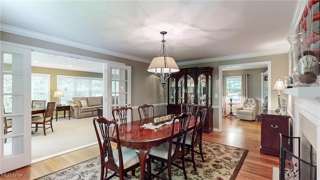 7700 Clarion Dr, Chagrin Falls, OH 44022 - dining area featuring light wood-style flooring, crown molding, and a fireplace