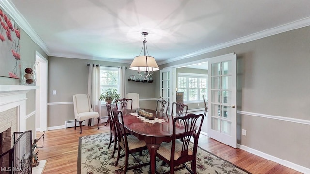 7700 Clarion Dr, Chagrin Falls, OH 44022 - dining room with a brick fireplace, light wood-style flooring, crown molding, a chandelier, and baseboards