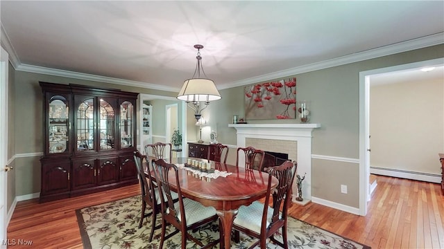 7700 Clarion Dr, Chagrin Falls, OH 44022 - dining space with a baseboard heating unit, wood finished floors, a fireplace, crown molding, and baseboards