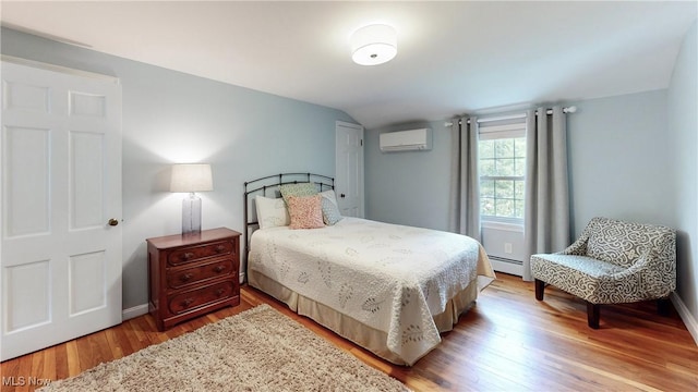 7700 Clarion Dr, Chagrin Falls, OH 44022 - bedroom featuring a wall unit AC, a baseboard heating unit, wood finished floors, baseboards, and vaulted ceiling