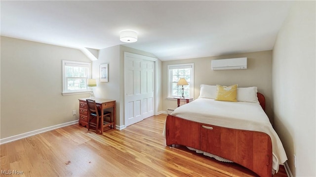 7700 Clarion Dr, Chagrin Falls, OH 44022 - bedroom with a wall unit AC, light wood finished floors, multiple windows, and vaulted ceiling