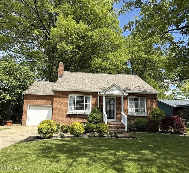 1089 Homestead Rd, South Euclid, OH 44121 - view of front facade with a garage, brick siding, driveway, a front yard, and a chimney