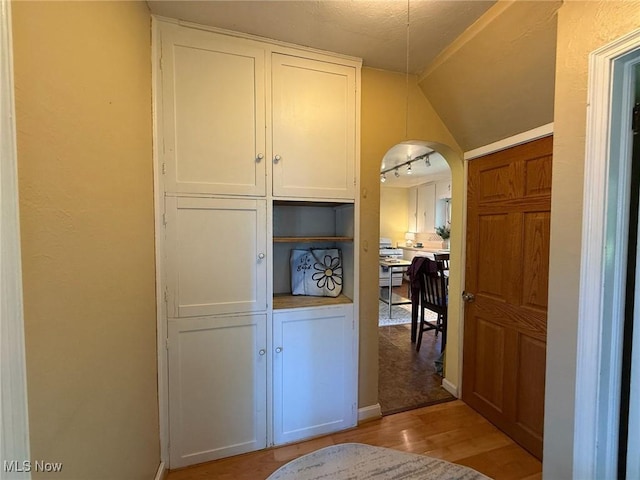 1089 Homestead Rd, South Euclid, OH 44121 - interior space featuring white cabinets, light wood-type flooring, arched walkways, and baseboards