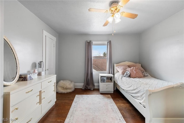 2445 Pigeon Run Rd SW, Massillon, OH 44647 - bedroom with dark wood finished floors, ceiling fan, baseboards, and a textured ceiling