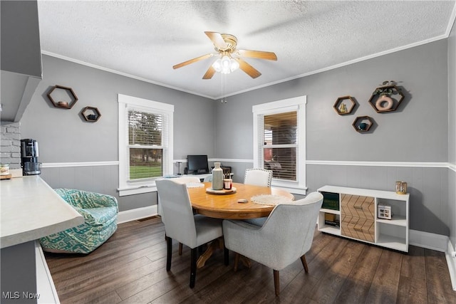2445 Pigeon Run Rd SW, Massillon, OH 44647 - dining room with a ceiling fan, dark wood-type flooring, a textured ceiling, a wainscoted wall, and ornamental molding