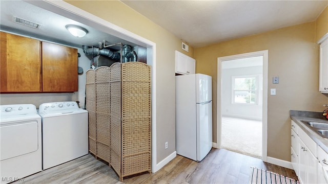 2364 Suncrest Dr, Cuyahoga Falls, OH 44221 - laundry area with independent washer and dryer, light wood-style flooring, a sink, and baseboards