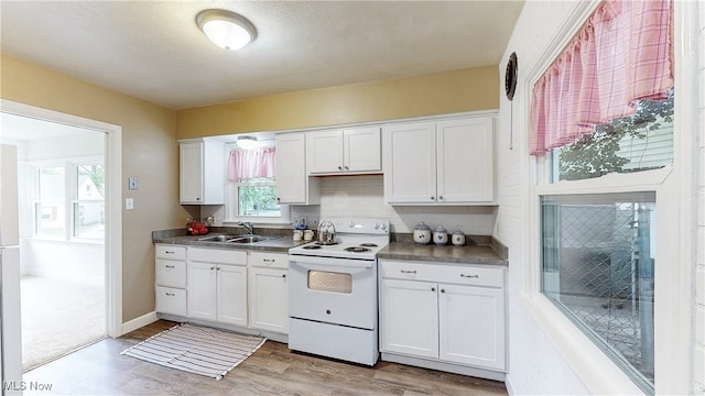 2364 Suncrest Dr, Cuyahoga Falls, OH 44221 - kitchen featuring white range with electric cooktop, a sink, white cabinets, and light wood finished floors