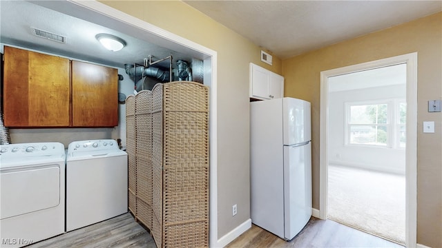2364 Suncrest Dr, Cuyahoga Falls, OH 44221 - washroom featuring cabinet space, independent washer and dryer, light wood-style floors, and baseboards