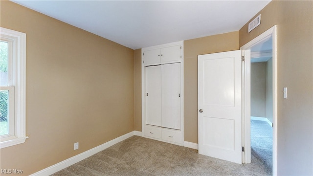 2364 Suncrest Dr, Cuyahoga Falls, OH 44221 - unfurnished bedroom featuring light colored carpet, multiple windows, baseboards, and a closet