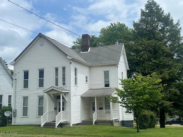 523 N Chestnut St, Barnesville, OH 43713 - view of front facade with a chimney, a porch, a front yard, and a shingled roof