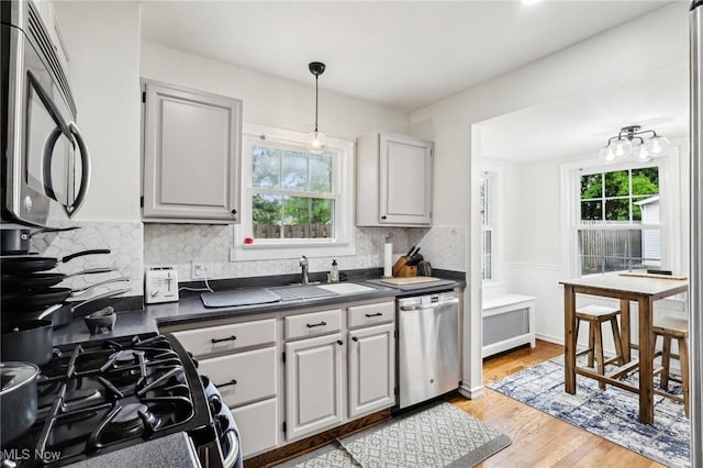 3945 Meadowbrook Blvd, University Heights, OH 44118 - kitchen with stainless steel appliances, a sink, dark countertops, wainscoting, and backsplash