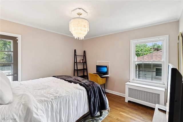 3945 Meadowbrook Blvd, University Heights, OH 44118 - bedroom featuring multiple windows, radiator heating unit, wood finished floors, a chandelier, and ornamental molding