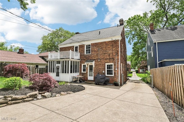 3945 Meadowbrook Blvd, University Heights, OH 44118 - rear view of house with a balcony, a sunroom, brick siding, a patio area, and a chimney