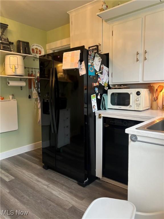 724 8th St, Struthers, OH 44471 - kitchen featuring black appliances, wood finished floors, light countertops, and white cabinets