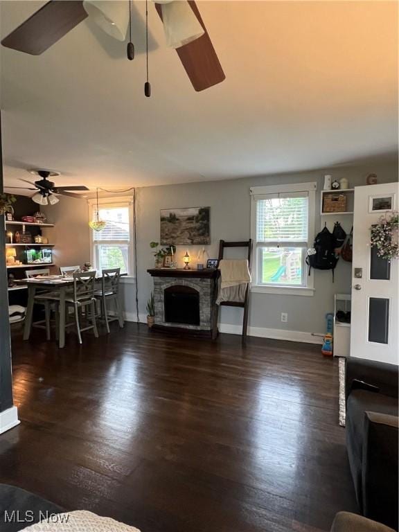 724 8th St, Struthers, OH 44471 - living room with wood finished floors, a ceiling fan, baseboards, and a fireplace