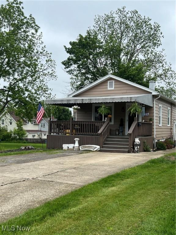 724 8th St, Struthers, OH 44471 - view of front of home with covered porch and a front lawn