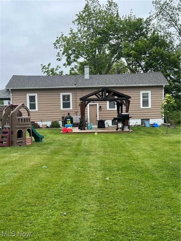 724 8th St, Struthers, OH 44471 - back of house featuring a gazebo, a lawn, a chimney, a playground, and roof with shingles