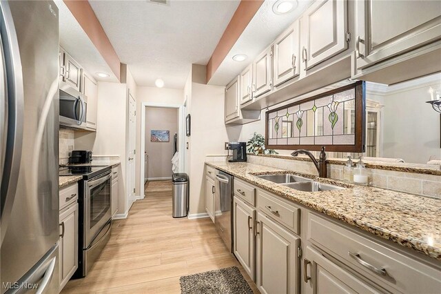 194 Lisa Ann Dr, Huron, OH 44839 - kitchen with appliances with stainless steel finishes, light wood-type flooring, a sink, recessed lighting, and light stone counters