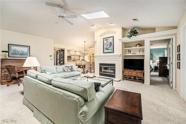 194 Lisa Ann Dr, Huron, OH 44839 - living room featuring light carpet, a ceiling fan, vaulted ceiling, a skylight, and a glass covered fireplace