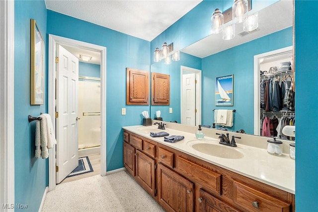 194 Lisa Ann Dr, Huron, OH 44839 - bathroom featuring a shower stall, baseboards, double vanity, and a spacious closet