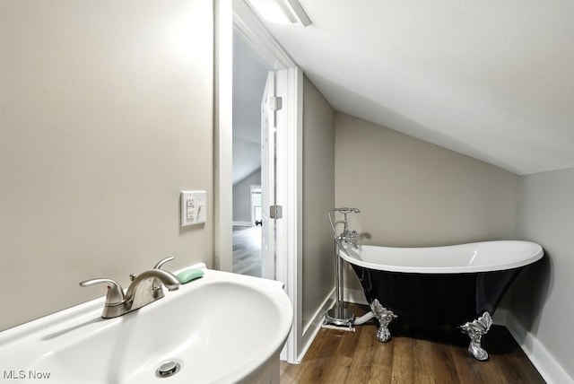 3136 Ellet Ave, Akron, OH 44312 - full bath with a sink, a freestanding bath, lofted ceiling, wood finished floors, and baseboards