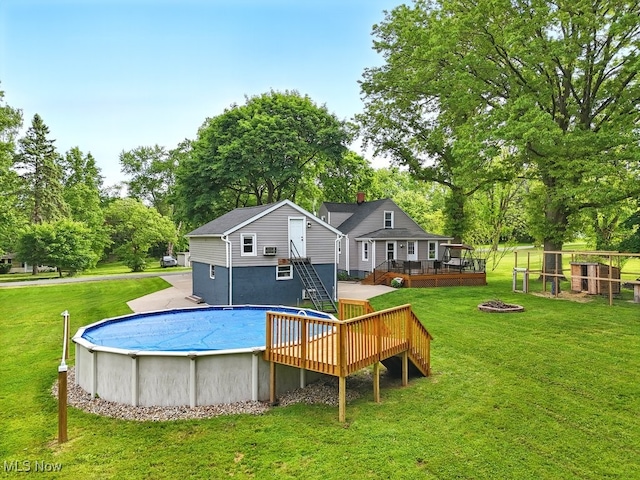 3136 Ellet Ave, Akron, OH 44312 - outdoor pool featuring a wooden deck, an outdoor fire pit, a lawn, and view of wooded area