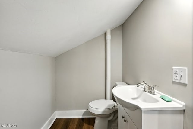 3136 Ellet Ave, Akron, OH 44312 - half bathroom with vanity, wood finished floors, baseboards, toilet, and vaulted ceiling