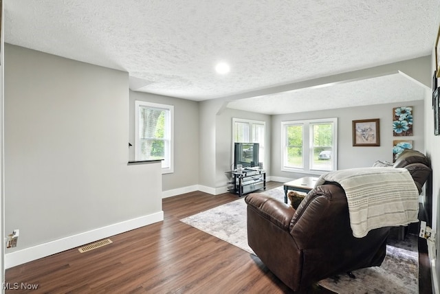 3136 Ellet Ave, Akron, OH 44312 - living room featuring arched walkways, baseboards, dark wood-style flooring, and a textured ceiling