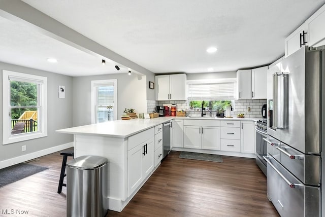 3136 Ellet Ave, Akron, OH 44312 - kitchen featuring appliances with stainless steel finishes, a peninsula, a sink, tasteful backsplash, and healthy amount of natural light