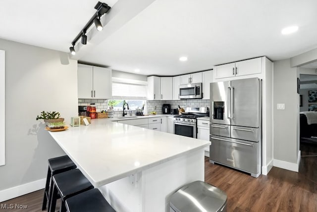 3136 Ellet Ave, Akron, OH 44312 - kitchen featuring stainless steel appliances, a peninsula, baseboards, a kitchen bar, and recessed lighting