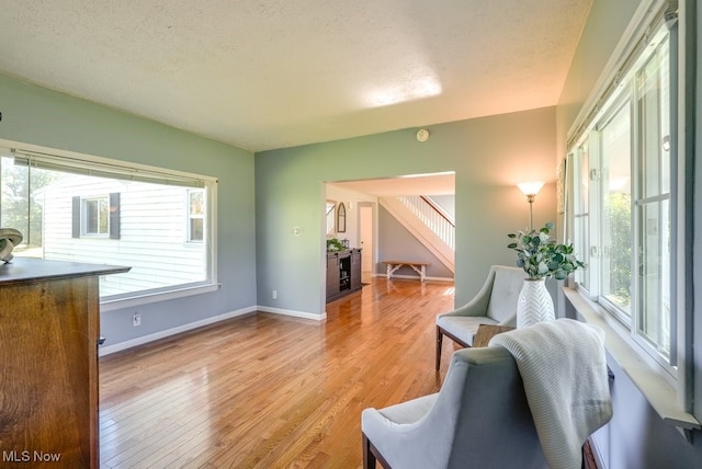 869 State Route 303, Streetsboro, OH 44241 - living room featuring light wood finished floors, baseboards, a textured ceiling, and a fireplace