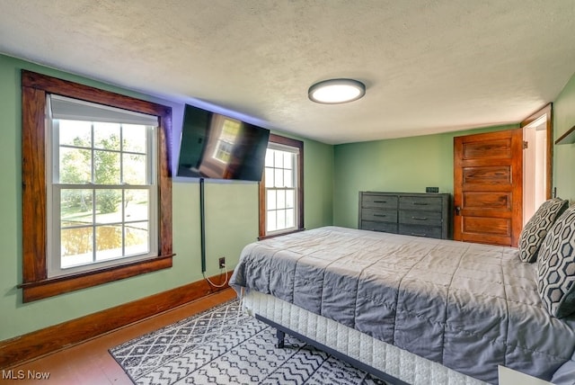 869 State Route 303, Streetsboro, OH 44241 - bedroom featuring a textured ceiling, wood finished floors, and baseboards