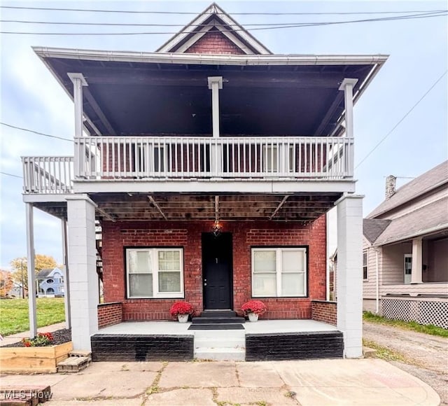 1008 6th St NW, Canton, OH 44703 - view of front facade with brick siding, a porch, and a balcony