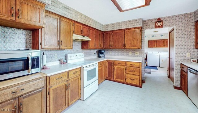 16000 Louisville St, Homeworth, OH 44634 - kitchen with stainless steel appliances, under cabinet range hood, wallpapered walls, washer and dryer, and brown cabinets