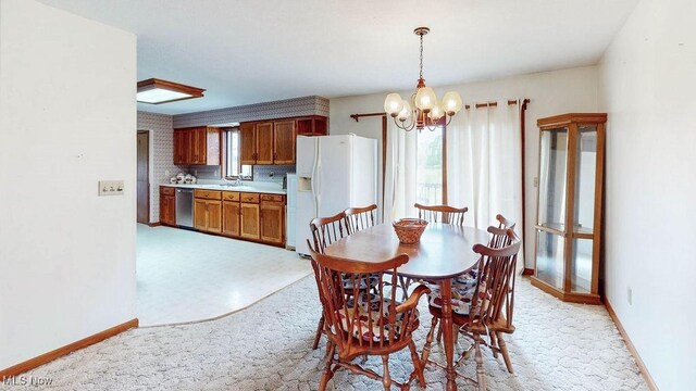 16000 Louisville St, Homeworth, OH 44634 - dining room featuring a chandelier, light colored carpet, and baseboards
