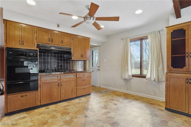 4017 Bellaire Ln, Peninsula, OH 44264 - kitchen featuring black oven, a warming drawer, under cabinet range hood, a ceiling fan, and tasteful backsplash