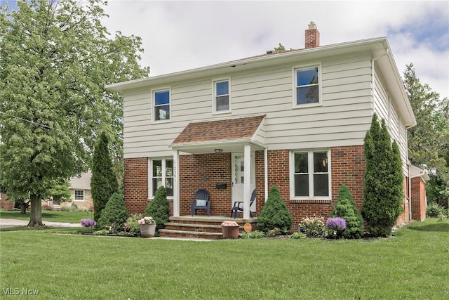2381 Charney Rd, University Heights, OH 44118 - view of front of house with brick siding, a chimney, and a front lawn