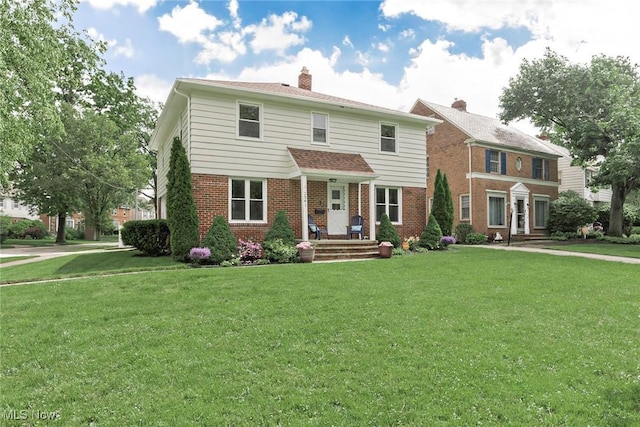 2381 Charney Rd, University Heights, OH 44118 - view of front facade featuring brick siding, a front yard, and a chimney