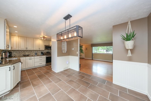 726 N Fork Way, Brunswick Hills, OH 44212 - kitchen featuring a sink, appliances with stainless steel finishes, a wainscoted wall, backsplash, and tile patterned floors